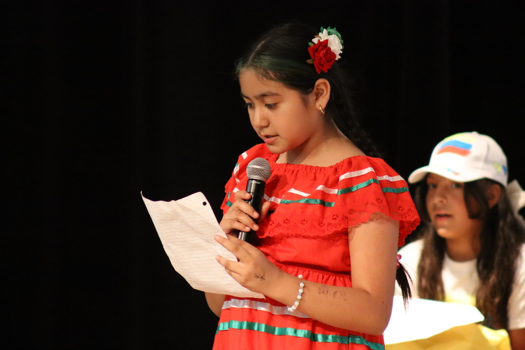 A young student reads from a paper at the Hispanic Heritage Assembly at Stratton Academy of the Arts.