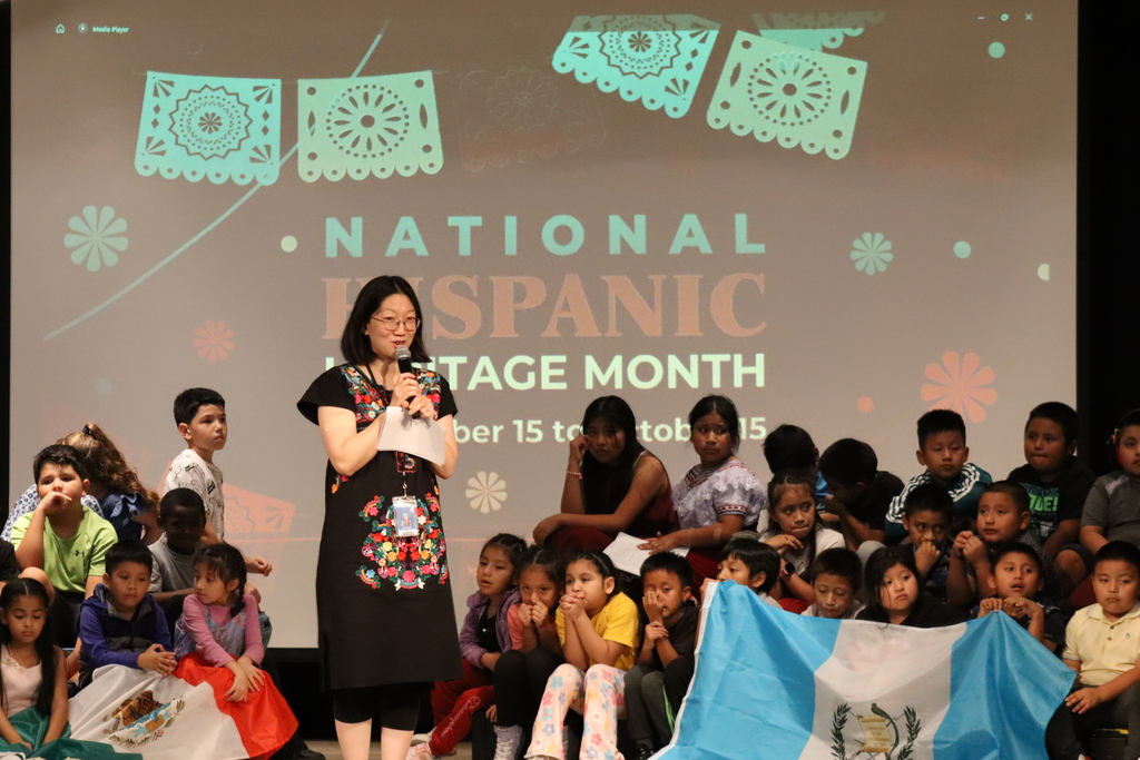 A teacher stands speakers during a Hispanic Heritage Month Assembly at Stratton Academy of the Arts.