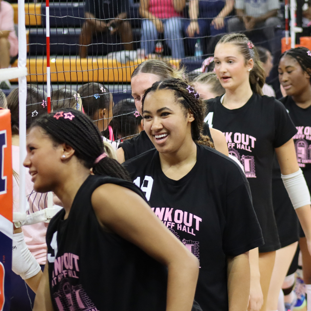 Central High School Volleyball players can be seen smiling and shaking hands with players from Centennial High School inside of Huff Hall.