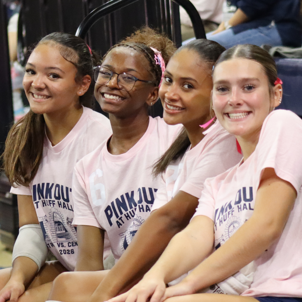 Centennial High School Volleyball Players smile for a photo inside of Huff Hall.
