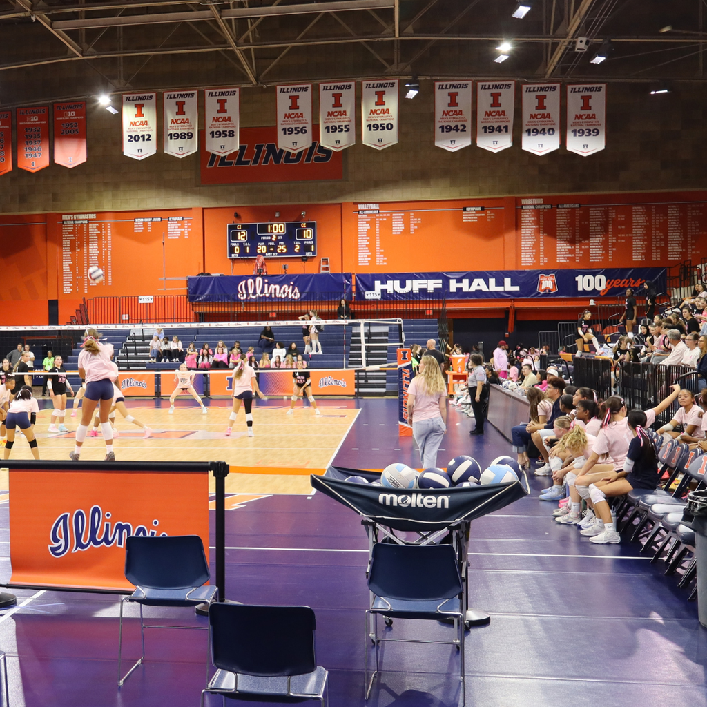 Central plays Centennial Volleyball at Huff Hall for Pink Out. The gym has blue and orange floor, spectators, players, banners.