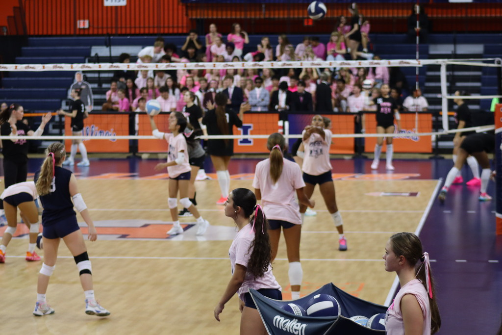 Central and Centennial volleyball players practice on court inside of Huff Hall. 