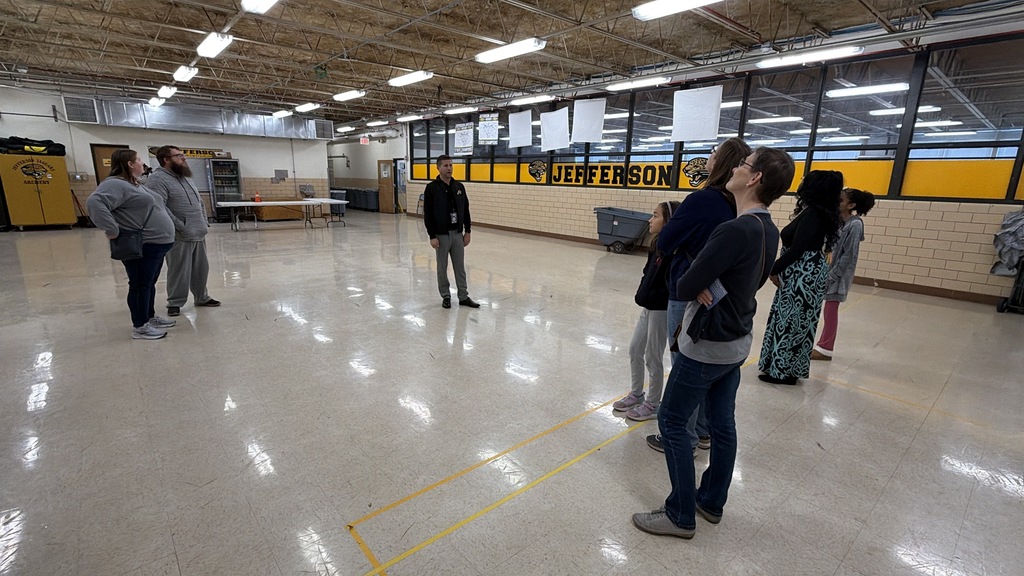Several people are gathered inside the Jefferson Middle School  as a referendum tour is being led.