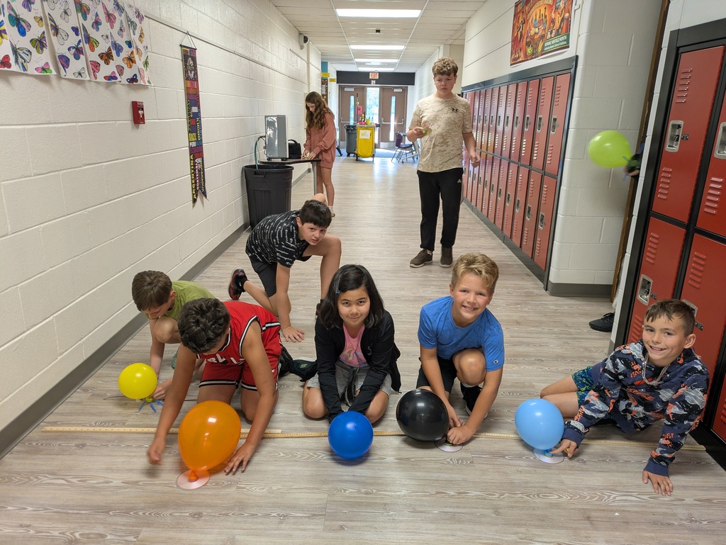 Students racing hovercrafts made with balloons