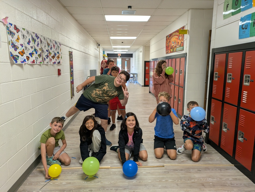 Students racing hover crafts they made with balloons 