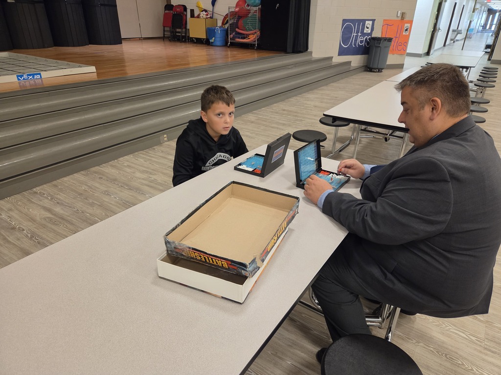 Student and teacher playing battleship at table