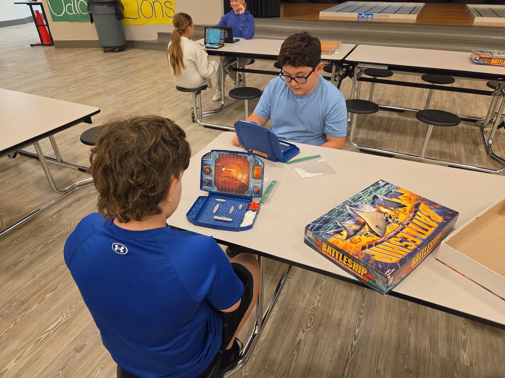 Students playing battleship at table