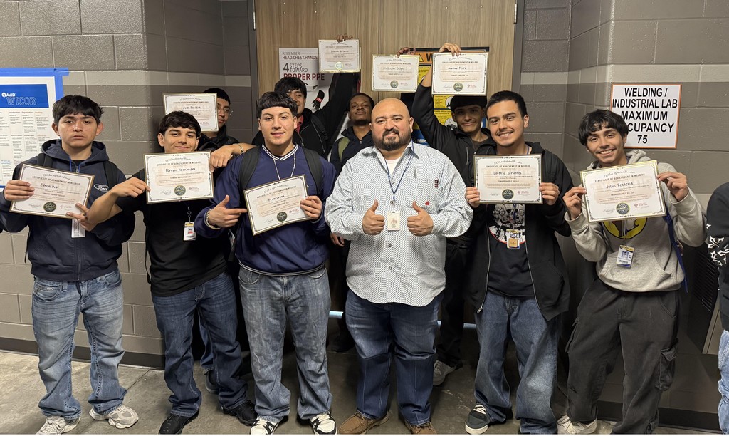 group of welding students and teacher holding certificates