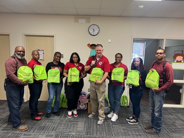 In the picture is Harvey Brown Staff Members accepting donations of backpacks and school supplies from LyondellBasell and BrandSafway. 