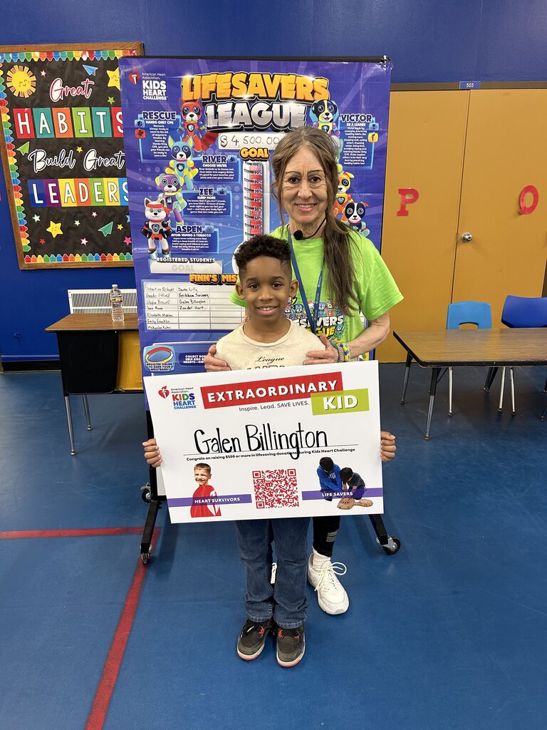 a student with a teacher holding up a sign