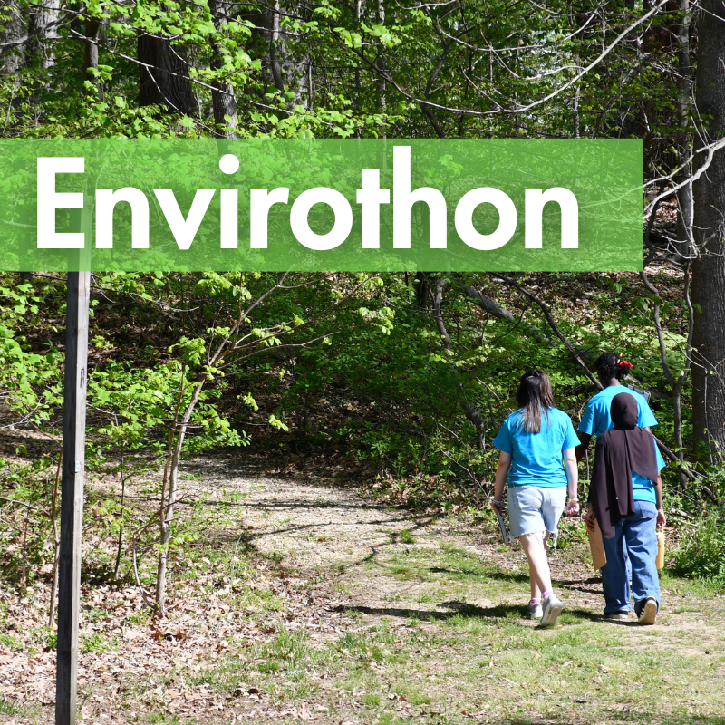 three kids walking down trail in forest with word "envirothon"