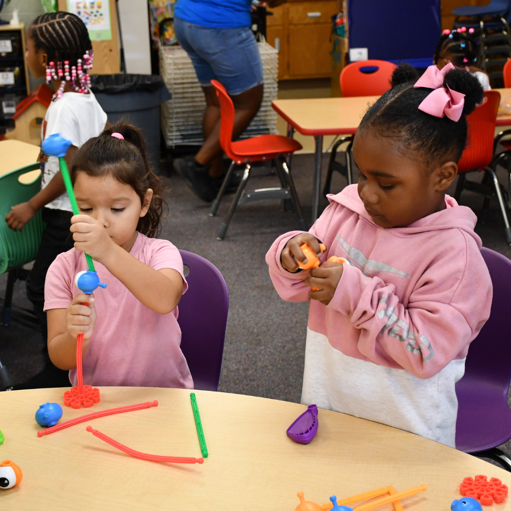 two young students playing with toys