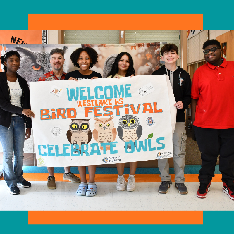 students standing and holding a banner that says "welcome westlake bird festival"