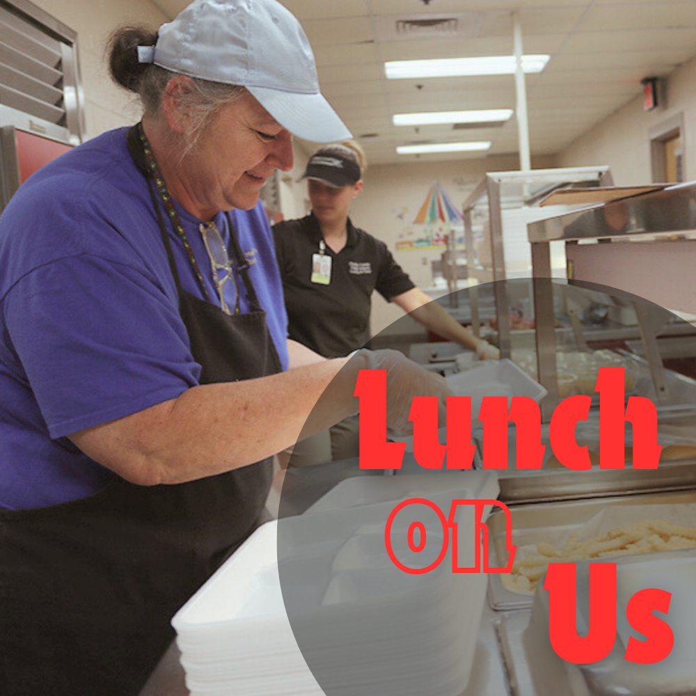 two employees working in the kitchen serving food
