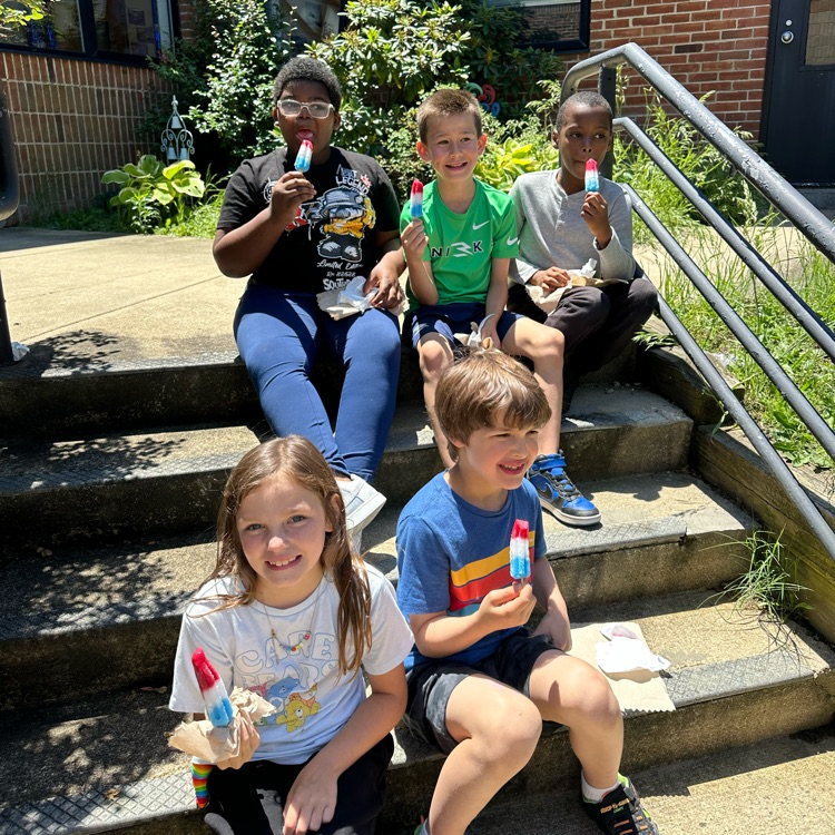 students enjoying a popsicle in the butterfly garden