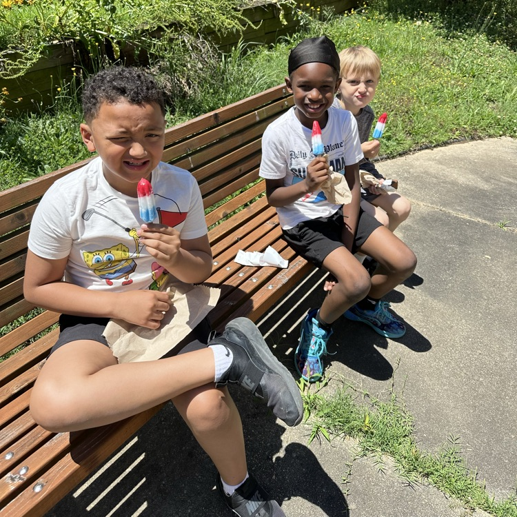 students enjoying a popsicle in the butterfly garden