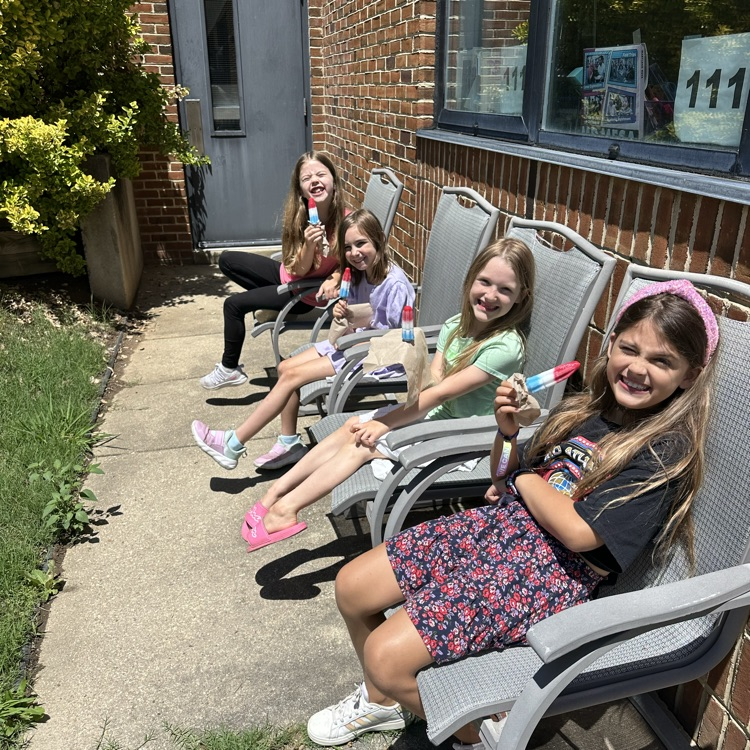 students enjoying a popsicle in the butterfly garden