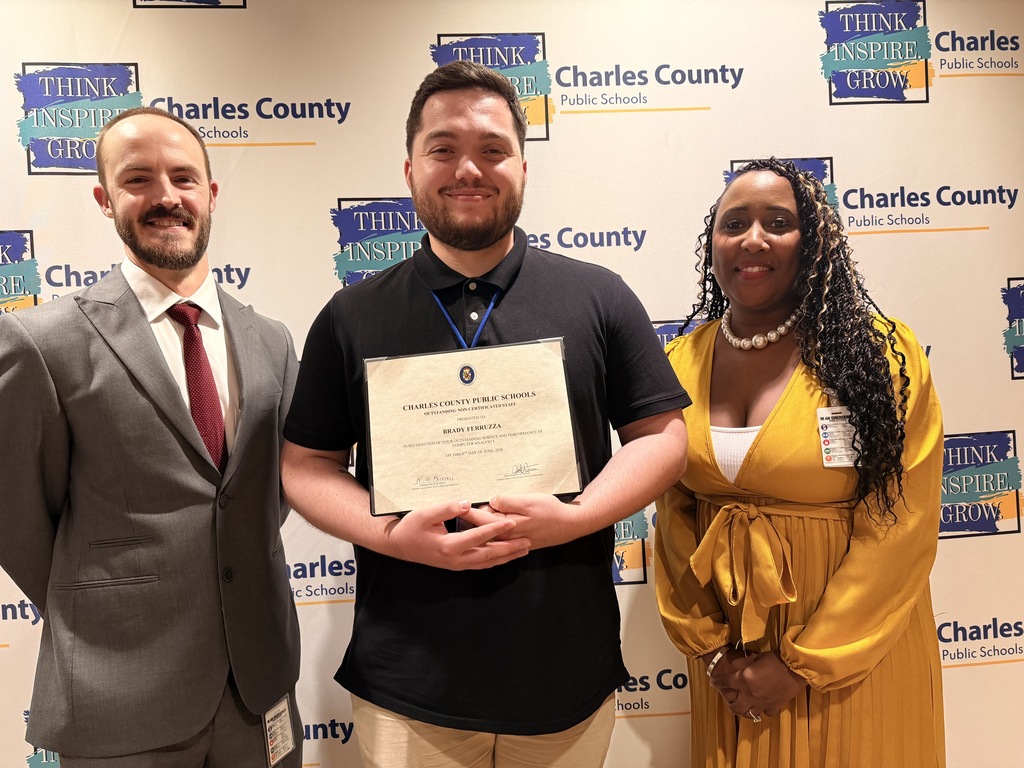 three people in front of a Charles County Public Schools background
