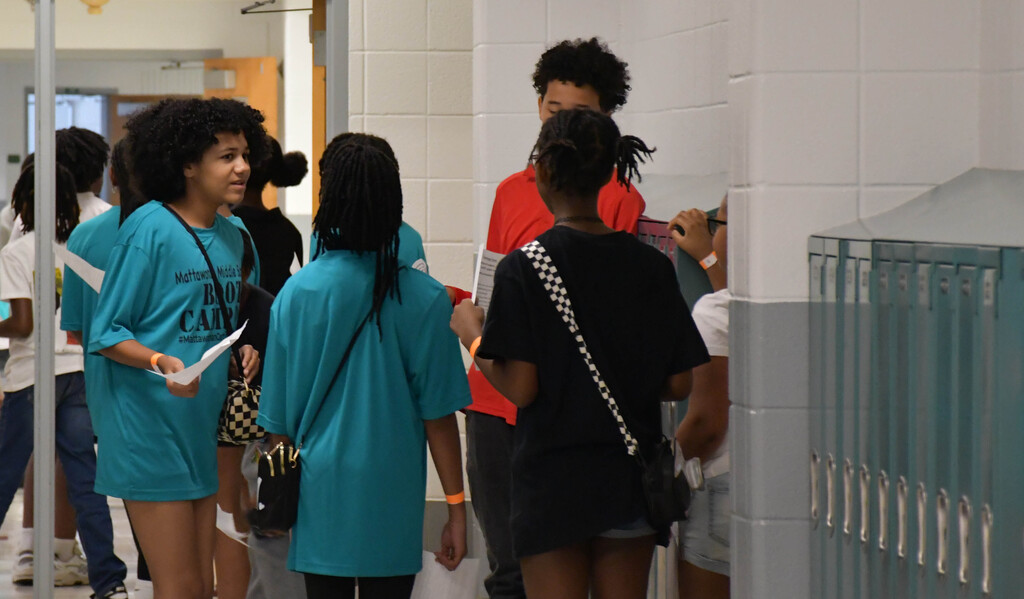Students standing in a circle in a school hallway talking
