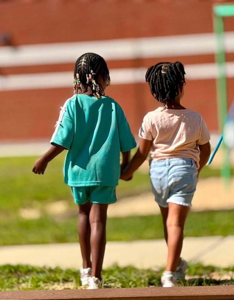 2 girls holding hands at recess 
