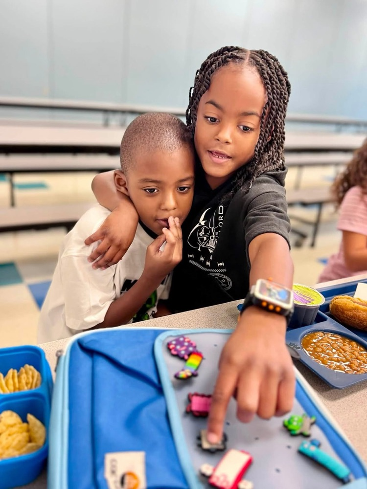 students with arms around each other in lunch room 