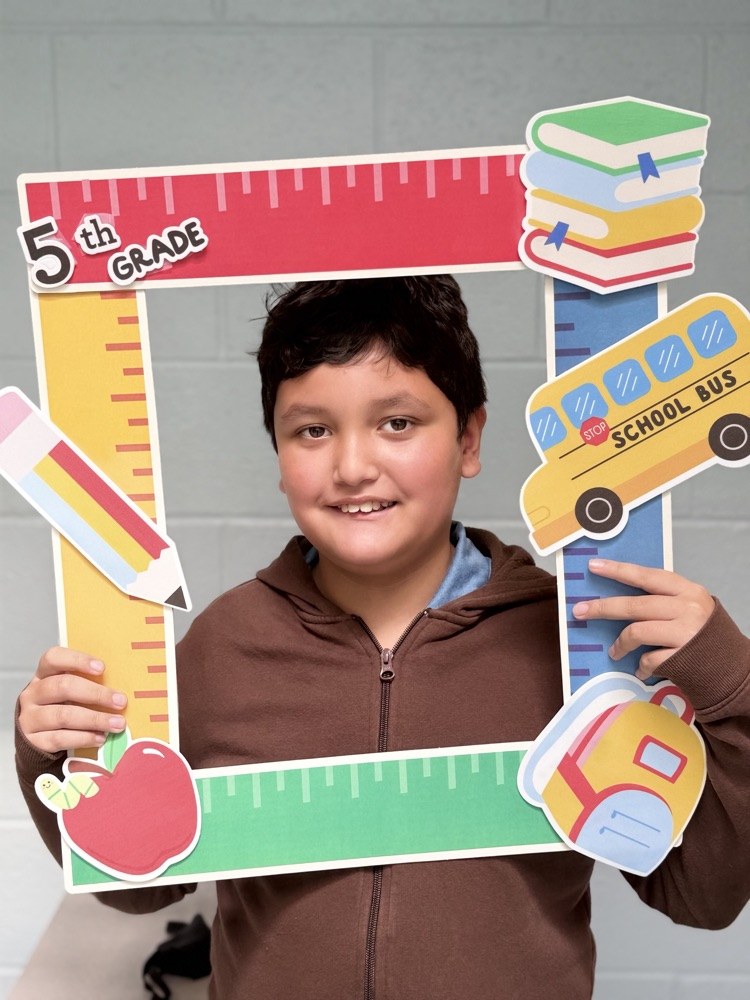 student holding a 5th grade sign 