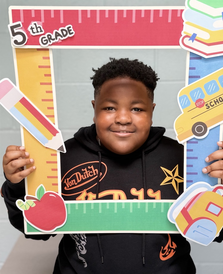 student holding a 5th grade sign 