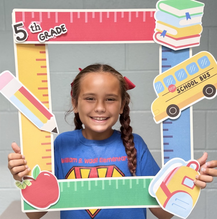 student holding a 5th grade sign 