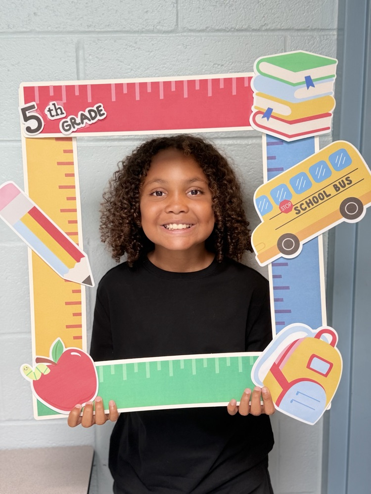 student holding a 5th grade sign 