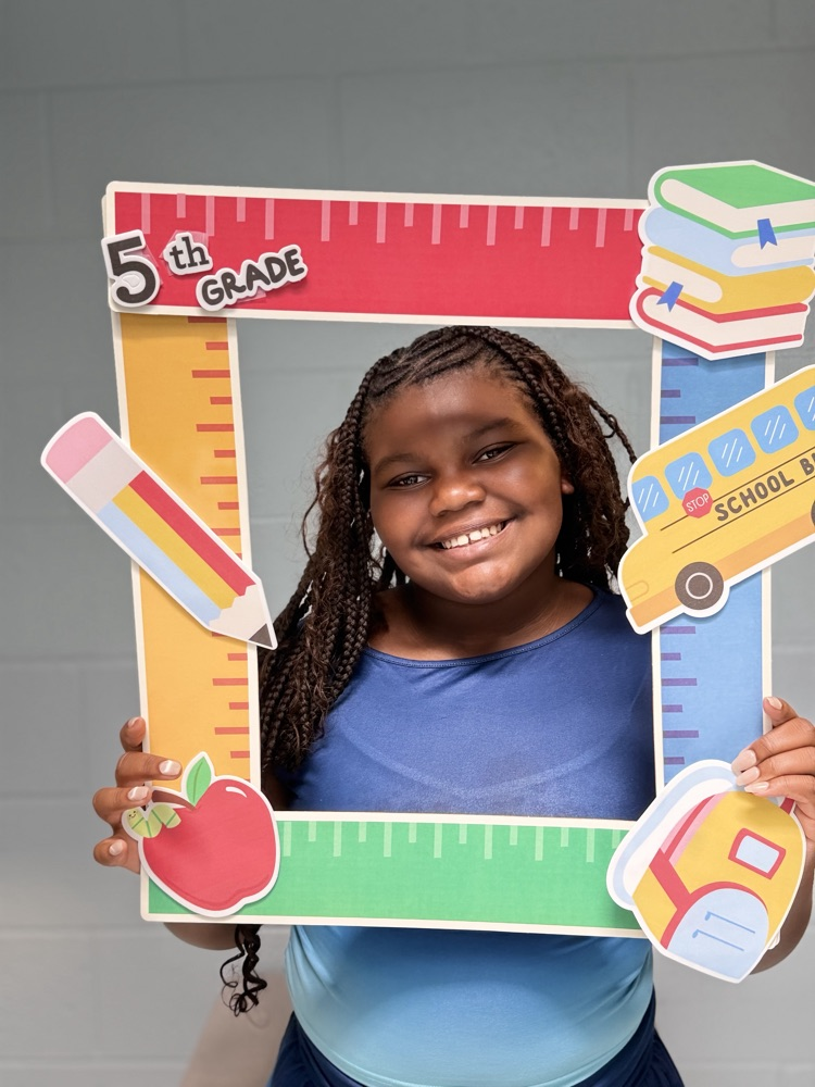 student holding a 5th grade sign 