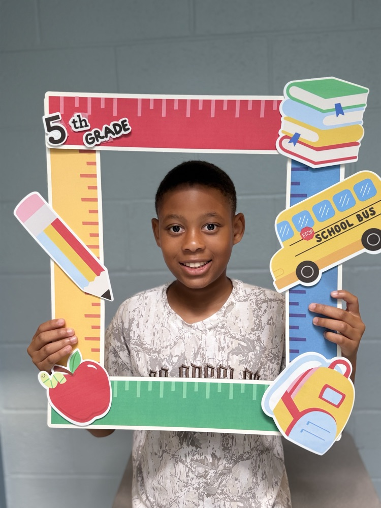 student holding a 5th grade sign 