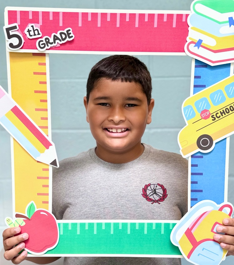 student holding a 5th grade sign