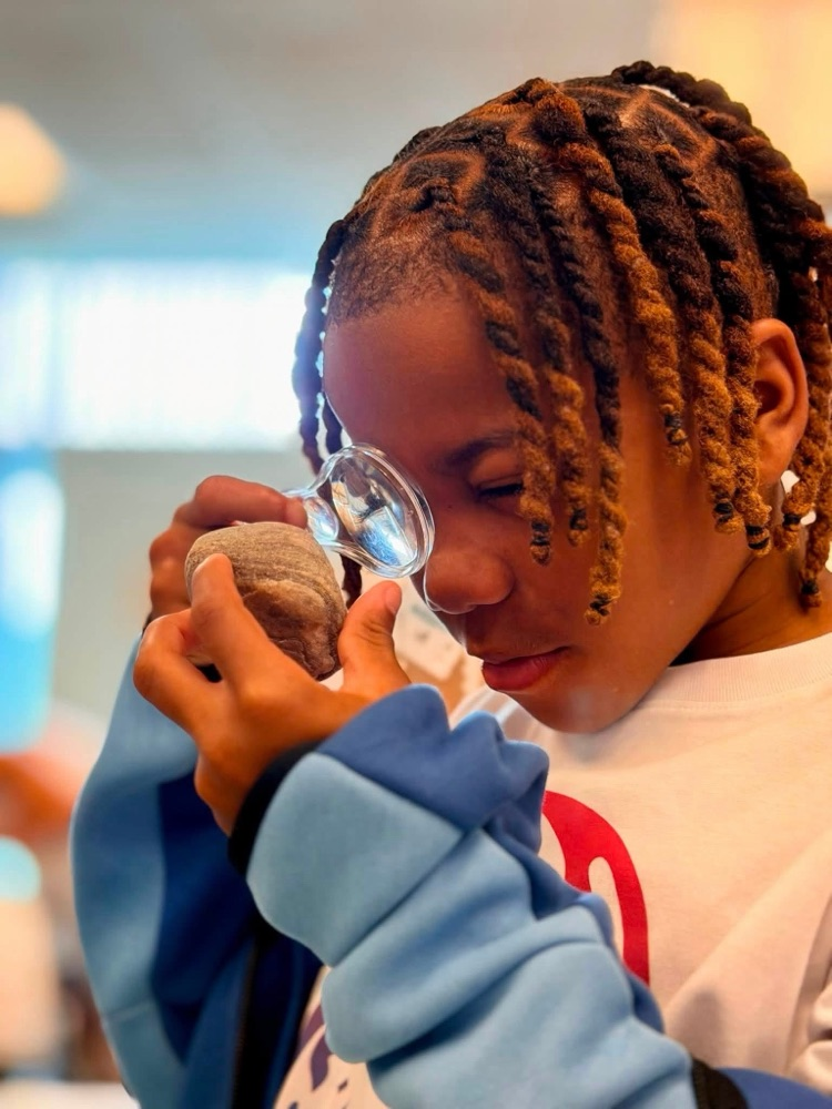 students looking at rocks with magnifying glass