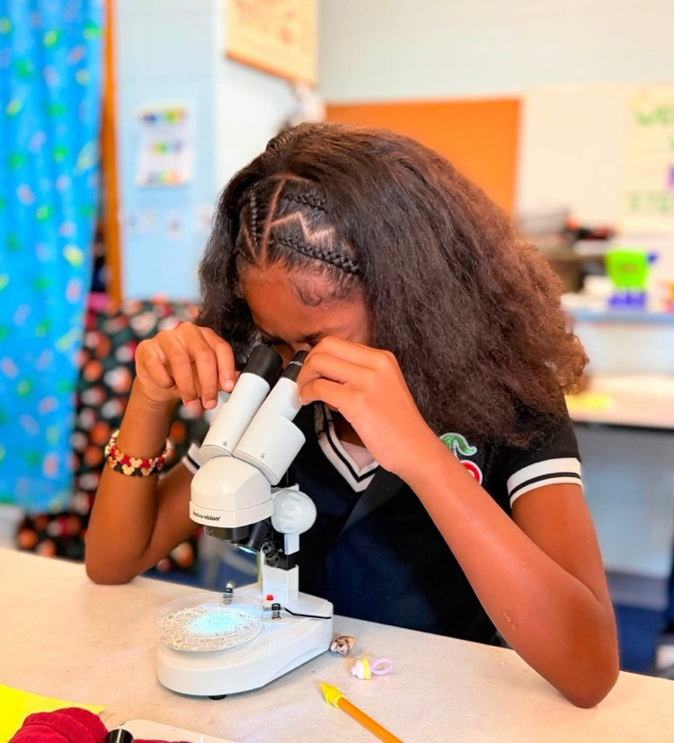 student looking in microscope