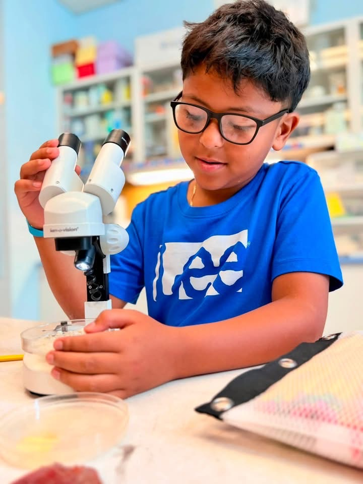 student looking in microscope