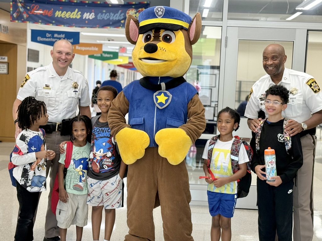 Sheriff Troy D. Berry and another sheriff’s officer pose with Dr. Mudd students and a Paw Patrol character during the school visit.