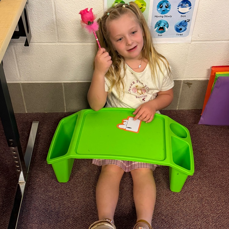 student writing on lap desk