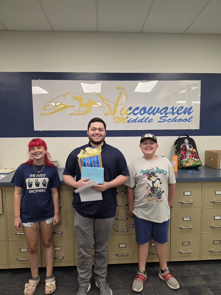 3 people standing in front of file cabinets and a school sign