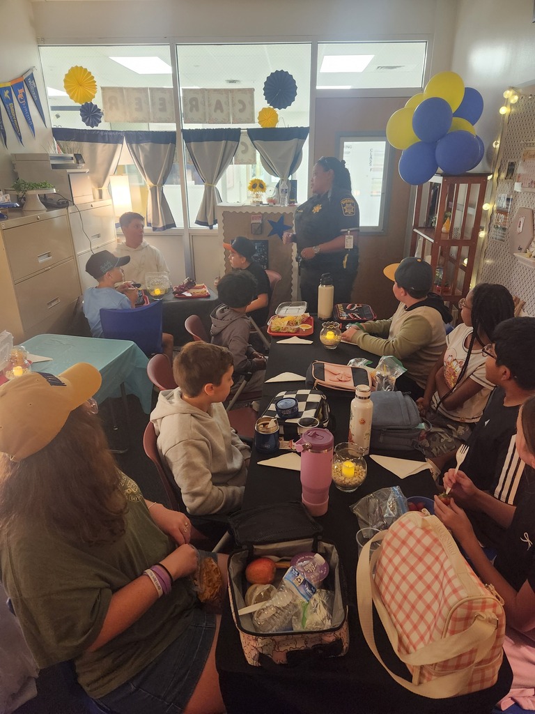 school officer talking with a group of students eating lunch