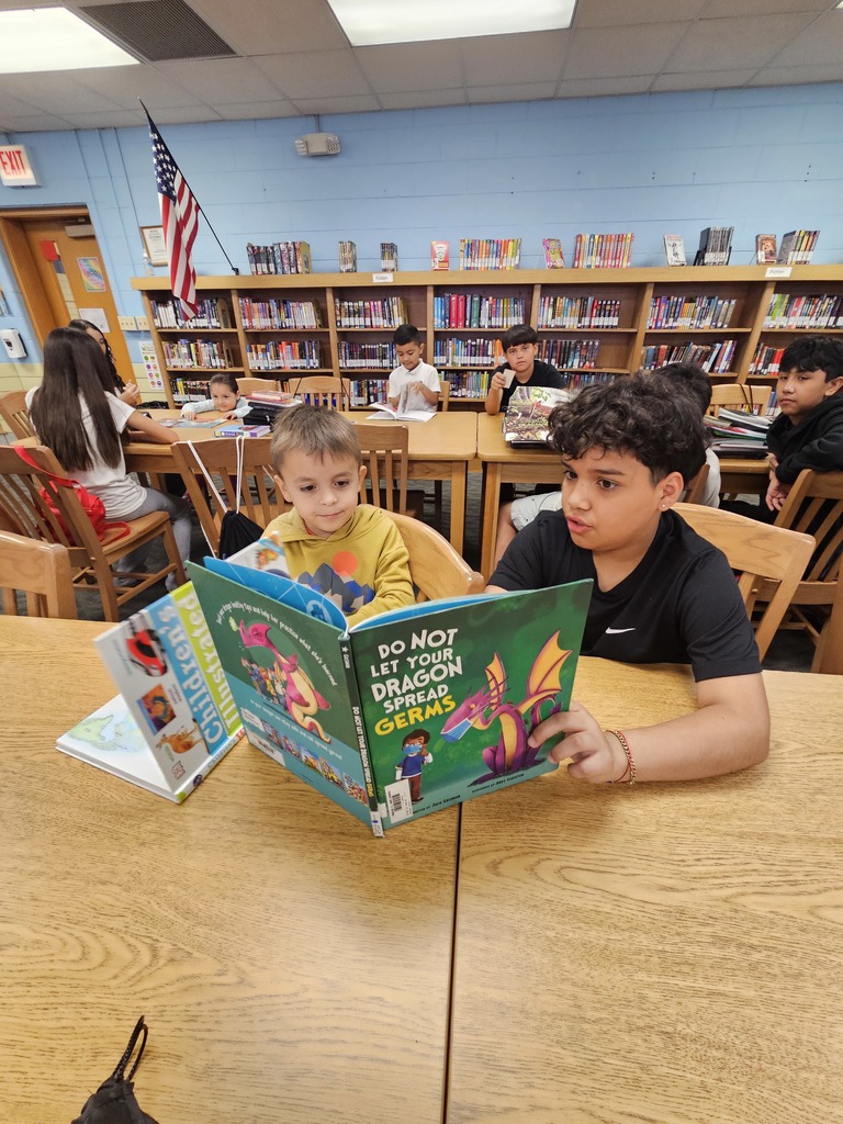 A kindergartener and a 7th grader read read a picture book together