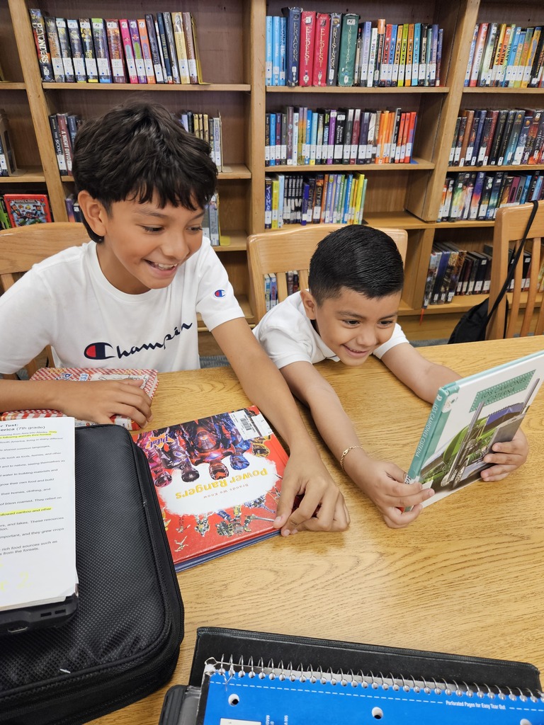 A kindergartener and a 7th grader read read a picture book together