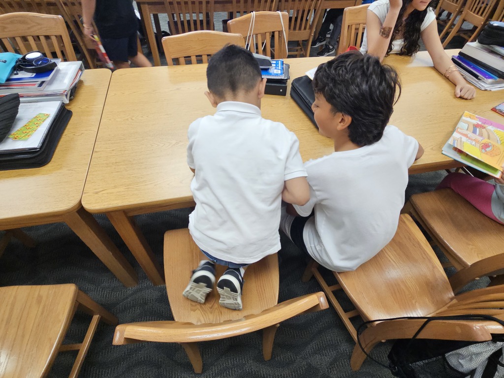 A kindergartener and a 7th grader read read a picture book together