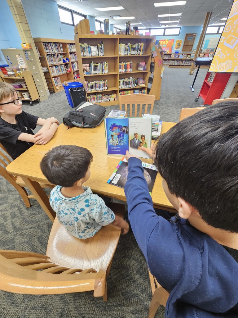 A kindergartener and a 7th grader read read a picture book together