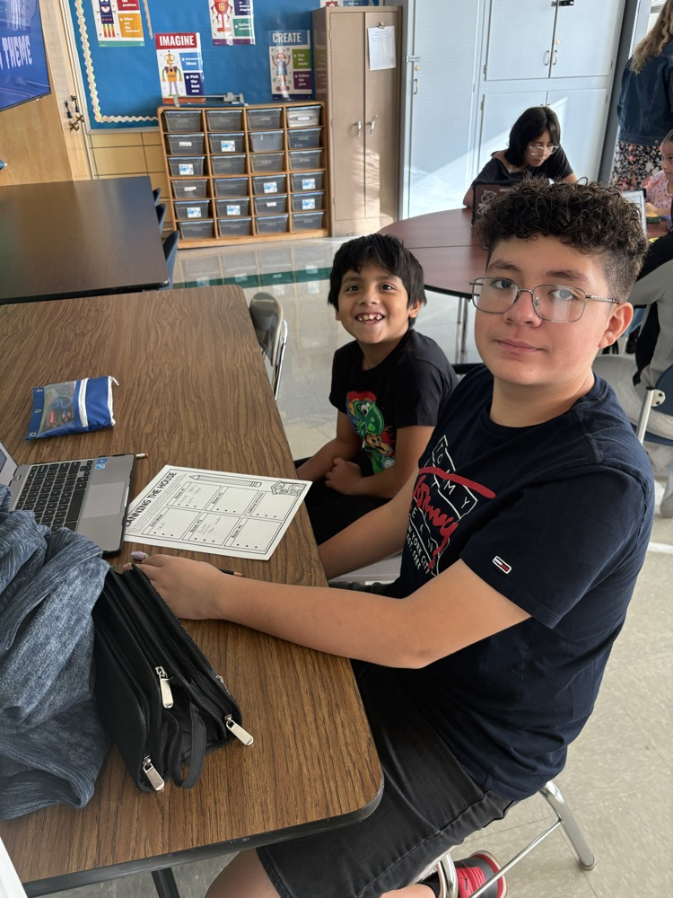 Second and Eighth graders meet with their buddies in the Steam Room planning their themes for their Haunted House activity.