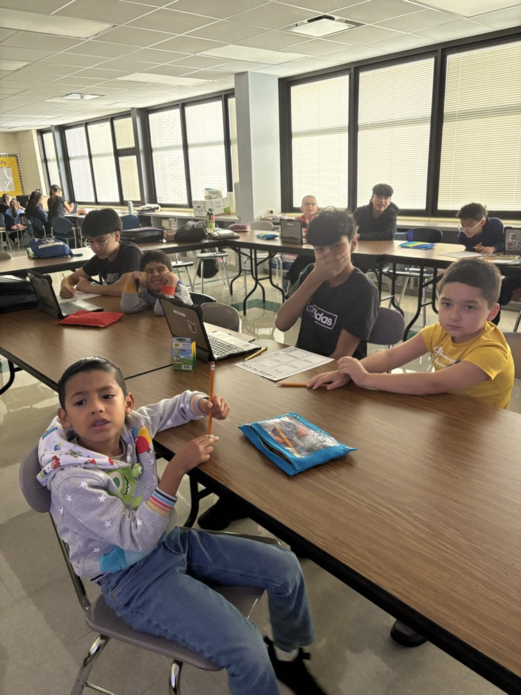 Second and Eighth graders meet with their buddies in the Steam Room planning their themes for their Haunted House activity.