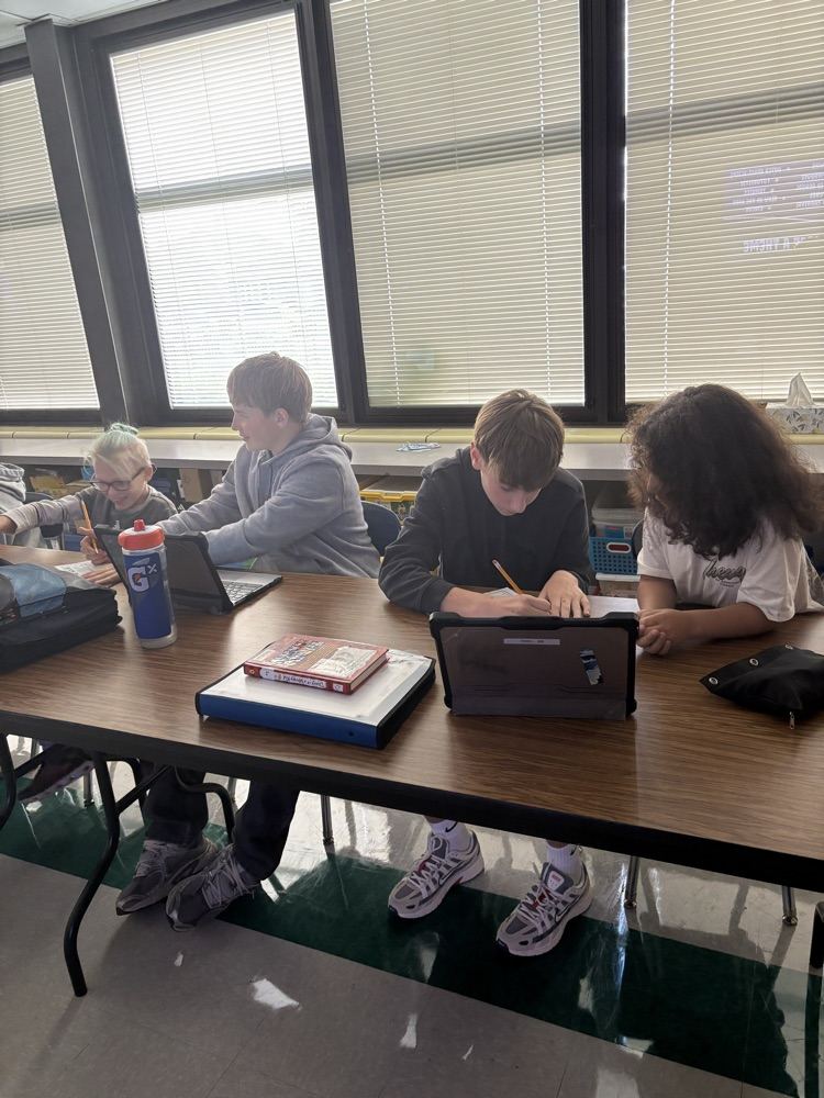 Second and Eighth graders meet with their buddies in the Steam Room planning their themes for their Haunted House activity.