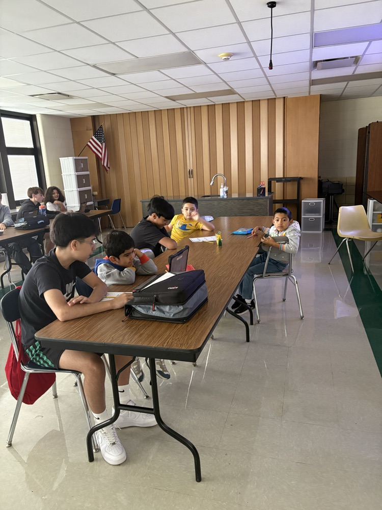 Second and Eighth graders meet with their buddies in the Steam Room planning their themes for their Haunted House activity.