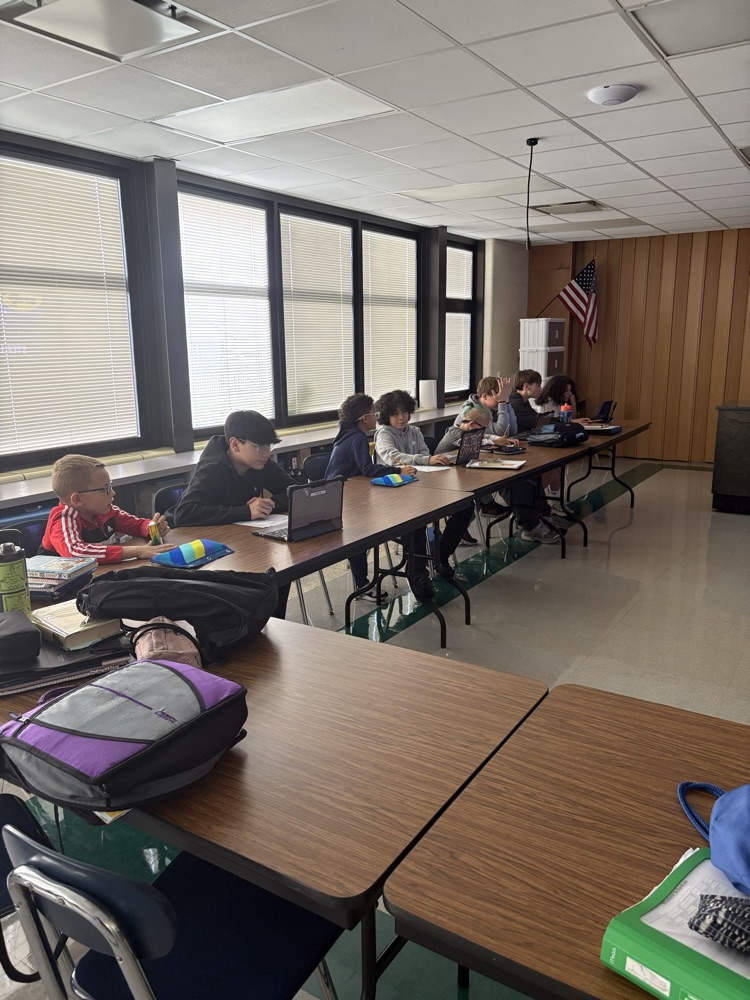 Second and Eighth graders meet with their buddies in the Steam Room planning their themes for their Haunted House activity.