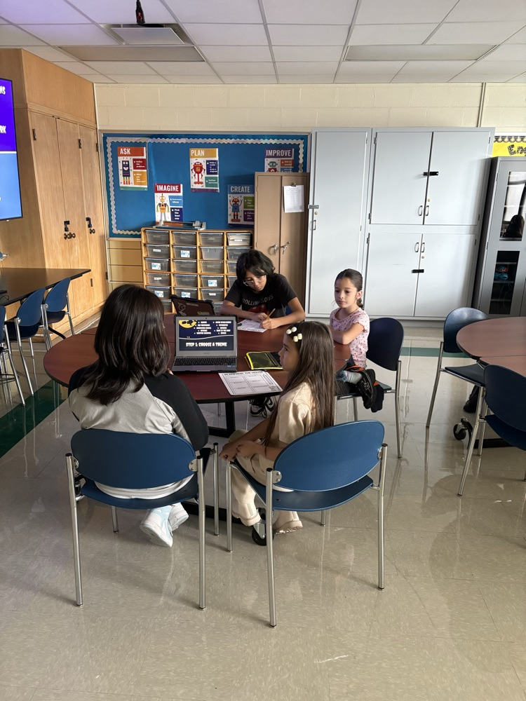 Second and Eighth graders meet with their buddies in the Steam Room planning their themes for their Haunted House activity.