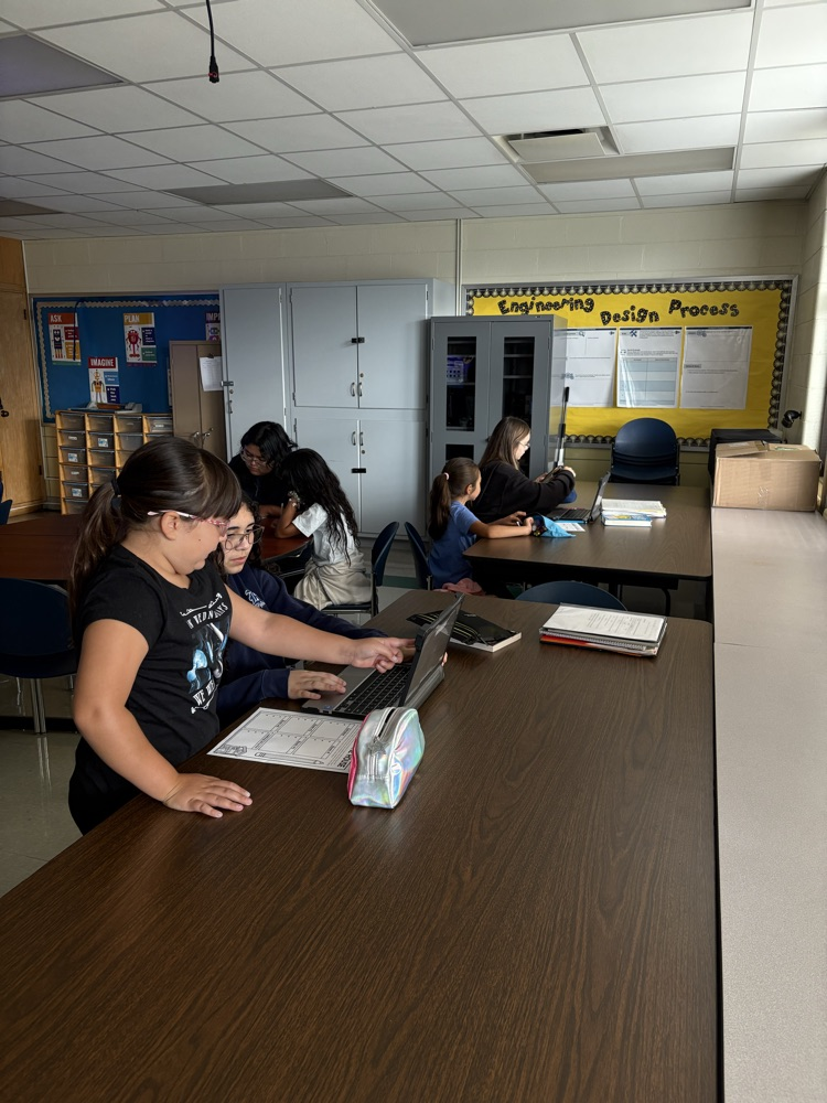 Second and Eighth graders meet with their buddies in the Steam Room planning their themes for their Haunted House activity.